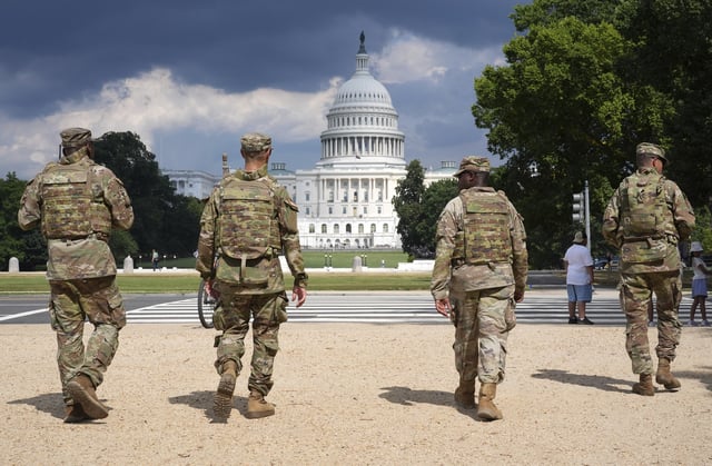 District of Columbia National Guard soldiers patrol on the National Mall, Thursday, August 14, 2025, in Washington. The U.S. Capitol is seen in the distance. (AP Photo/Jacquelyn Martin)