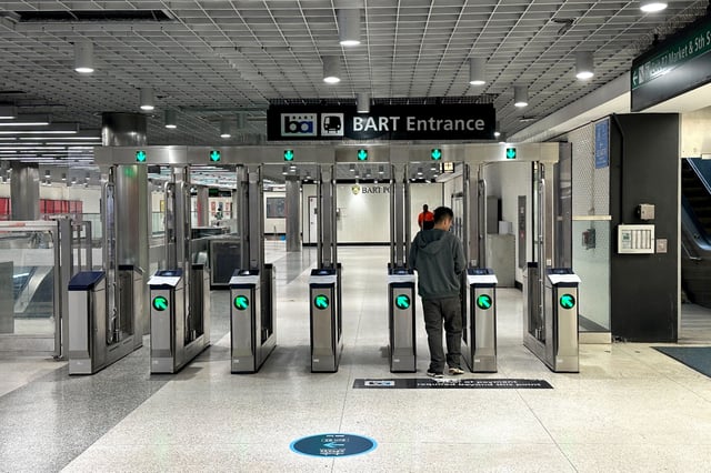 A BART commuter passes through a fare gate on Tuesday, July 1, 2025.