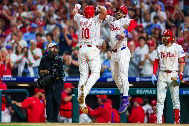 PHILADELPHIA, PENNSYLVANIA - AUGUST 19: J.T. Realmuto #10 of the Philadelphia Phillies celebrates with Bryce Harper #3 (R) after hitting a two-run home run in the eighth inning against the Seattle Mariners at Citizens Bank Park on August 19, 2025 in Philadelphia, Pennsylvania.