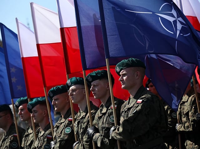 In Warsaw, Poland, on August 15, 2025, Polish Army soldiers carry the Polish and NATO flags during a military parade along a highway on the occasion of Polish Armed Forces Day. On August 15, Polish Army Day is celebrated. It is established in memory of the victorious Battle of Warsaw in 1920, fought during the Polish-Bolshevik War. On this occasion, celebrations and picnics with the participation of soldiers are organized throughout the country. A military parade with the participation of the President of the Republic of Poland, Karol Nawrocki, passes through the capital. (Photo by Klaudia Radecka/NurPhoto via Getty Images)