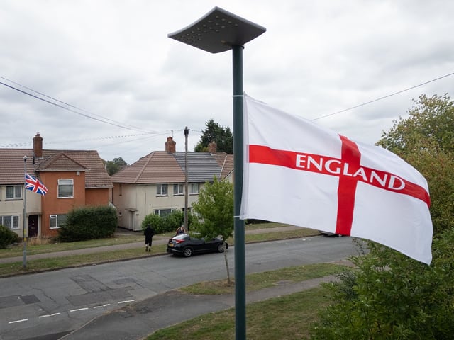 BIRMINGHAM, ENGLAND - AUGUST 18: A Union Flag and George Cross Flag fly above a residential street on August 18, 2025 in Birmingham, England. Birmingham City Council has removed Union and England flags installed by local groups, who say they are hanging them across the Weoley Castle and Northfield areas as an "act of patriotism." The Labour-run council has said the move is part of planned maintenance works to install energy-efficient LED lighting, but residents in favor of the British flags allege the council has applied a double standard by not removing Palestinian flags hung in other areas of the city. The flags of Britain have taken on a complexity of meaning over the centuries as symbols of national unity, empire, and protest, steeped in a rich history of both pageantry and controversy. (Photo by Leon Neal/Getty Images)