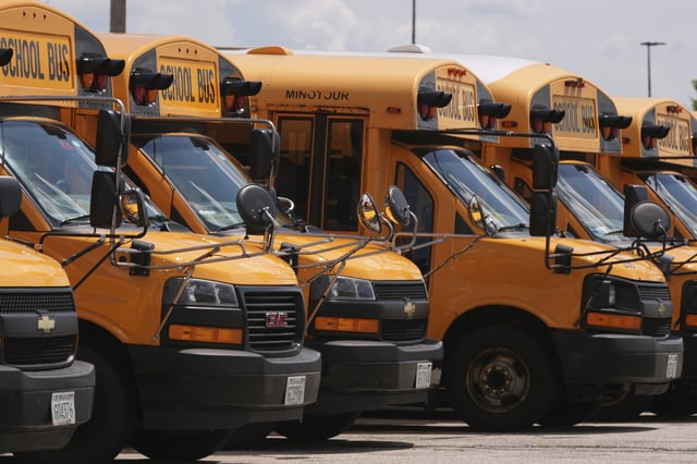 School buses are lined up in a storage lot, Thursday, Aug. 14, 2025, in Manchester, N.H.