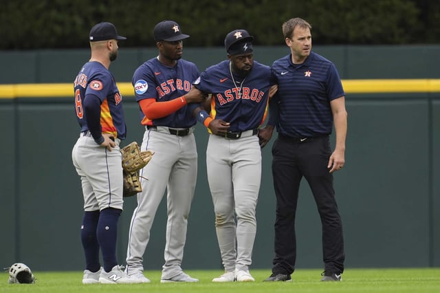 Astros center fielder Taylor Trammell (second from right) is helped after being injured attempting to catch a fly ball during the first inning Wednesday. Trammell was later carted off the field.