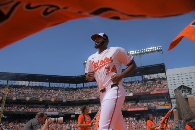 Baltimore Orioles relief pitcher Felix Bautista runs among the team’s banners as he and the rest of the team are introduced during the Orioles’ 8-5 home opener victory against the Boston Red Sox at Oriole Park at Camden Yards. (Karl Merton Ferron/Staff)