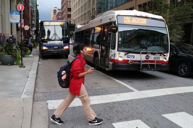 A Pace #755 bus and a CTA #126 bus travel on Jackson Boulevard at Clinton Street in Chicago on Aug. 18, 2025. (Terrence Antonio James/Chicago Tribune)