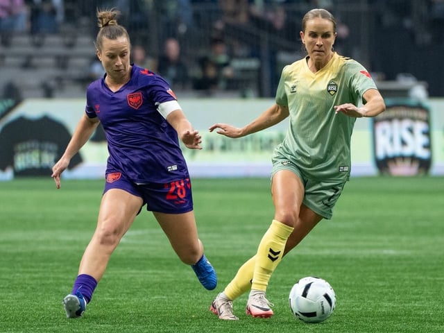 Calgary Wild's Meggie Dougherty Howard and Vancouver Rise's Nicole Stanton vie for the ball during the first half of an NSL match in Vancouver on Wednesday, April 16, 2025.