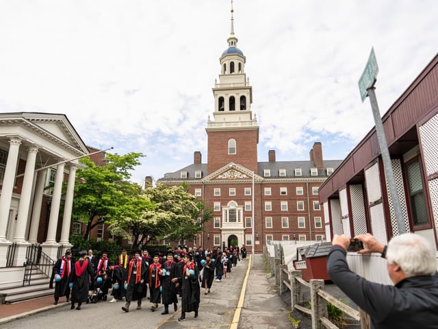Harvard University students wearing graduation gowns walk through Harvard Square in Cambridge, Massachusetts, US, on Thursday, May 29, 2025. US President Donald Trump said Harvard University should cap foreign student enrollment at 15%, ratcheting up his effort to force policy changes at the elite institution. Photographer: Mel Musto/Bloomberg