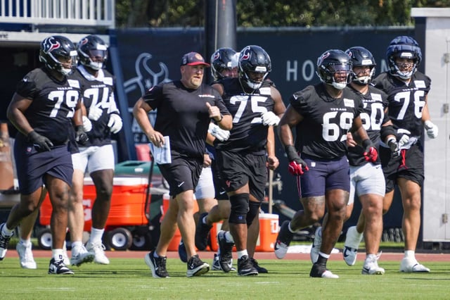 Houston Texans offensive linemen jog across the field during an NFL training camp practice at Houston Methodist Training Center in Houston, Wednesday, Aug. 20, 2025.