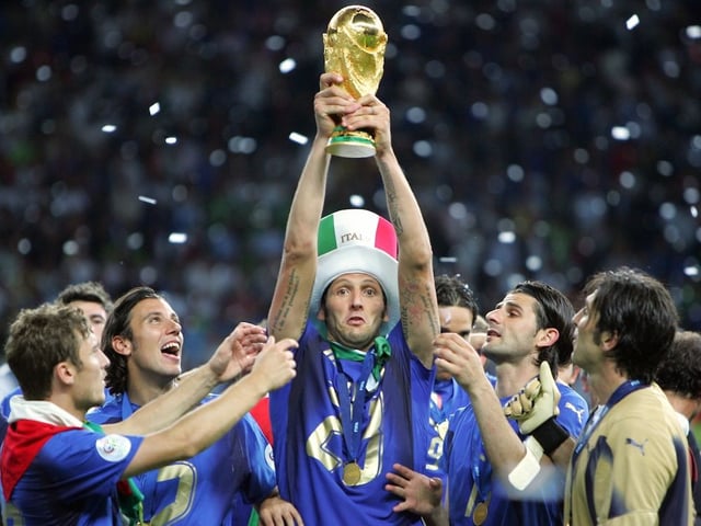 Italian defender Marco Materazzi holds up the 2006 World Cup trophy after Italy won their final football match against France at Berlin's Olympic Stadium in 2006.  