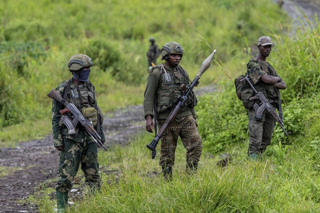 M23 rebels stand with their weapons, in Kibumba, DRC, Dec. 23, 2022 (AP photo by Moses Sawasawa).