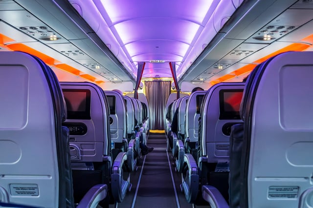 Airplane cabin aisle during a night flight.