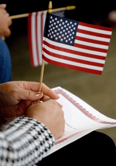 A woman holds an American flag as she waits to be sworn in at the naturalization ceremony at the Illinois State Fair on Wednesday, Aug. 13, 2025. The Trump administration seeks to scrutinize whether citizenship applicants have "good moral character."