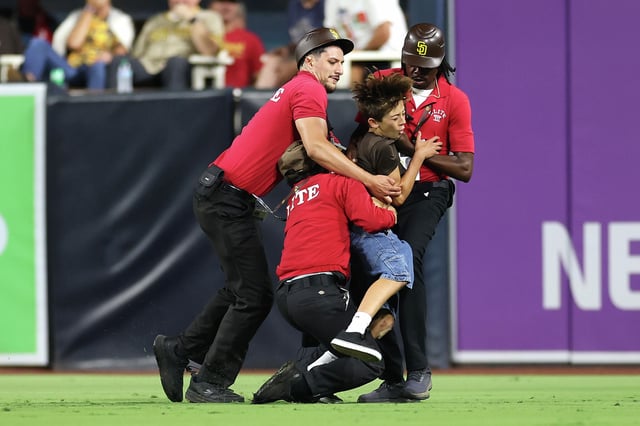 A young fan is tackled by security after running onto the field during the eighth inning of a game between the San Francisco Giants and the San Diego Padres at Petco Park on Aug. 19, 2025, in San Diego, Calif.