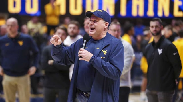 West Virginia Mountaineers head football coach Rich Rodriguez speaks to the crowd during a timeout during the first half against the Cincinnati Bearcats at WVU Coliseum. Mandatory Credit: Ben Queen-Imagn Images