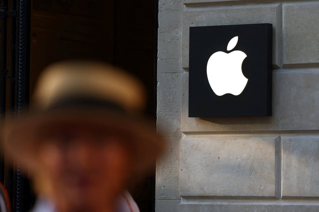 A woman walks past an Apple logo at an Apple store in Paris, France, August 17, 2025. REUTERS/Abdul Saboor/File Photo