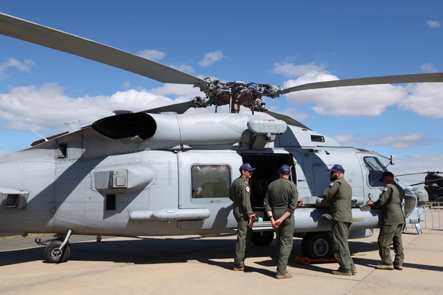 Naval aviators stand near a MH-60R Seahawk Romeo during the Australian International Airshow in Avalon, Australia March 25, 2025. REUTERS/Hollie Adams/File Photo