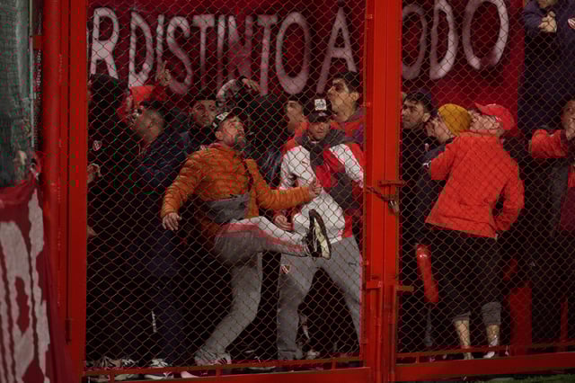Hinchas de Independiente intentan abrir un portón en el estadio del Rojo de Avellaneda. (AP)