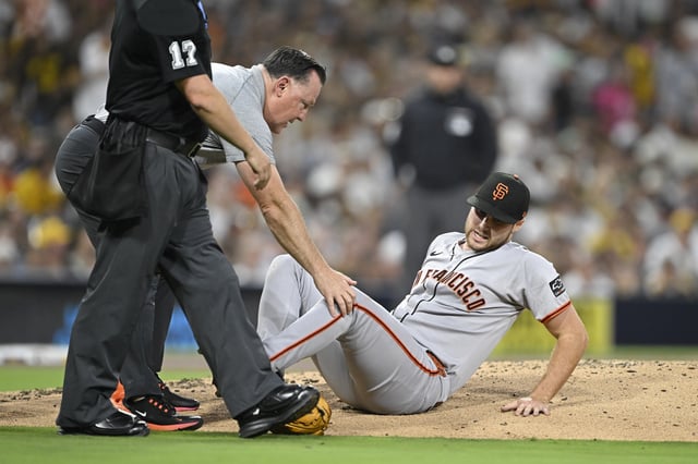 Aug 20, 2025; San Diego, California, USA; San Francisco Giants starting pitcher Landen Roupp (65) is looked at by a trainer after being hit by a ball hit by San Diego Padres right fielder Ramon Laureano (5) during the third inning at Petco Park. Mandatory Credit: Denis Poroy-Imagn Images