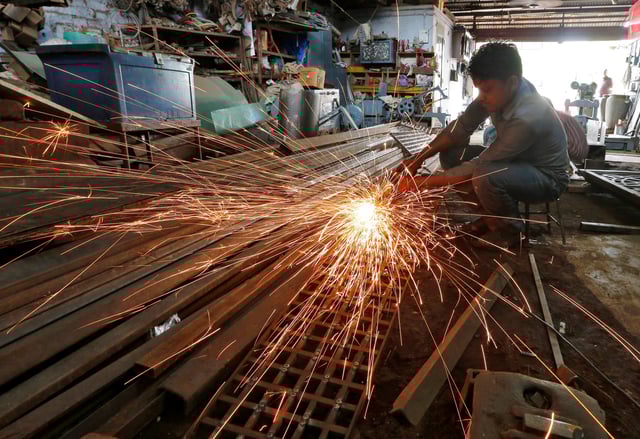 A worker grinds a metal gate inside a household furniture manufacturing factory in Ahmedabad, India, July 1, 2016. REUTERS/Amit Dave/ File Photo