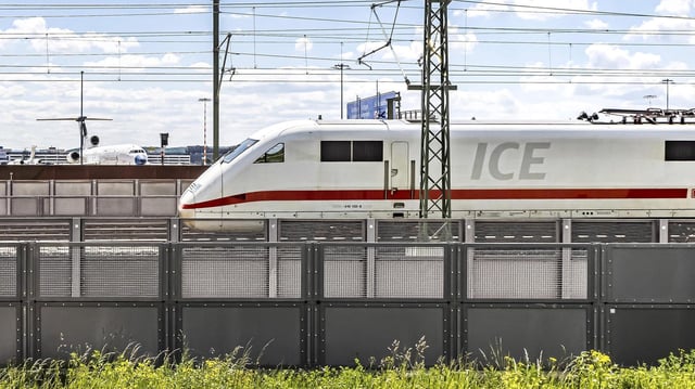 Eine ICE der Deutschen Bahn fährt am Stuttgarter Flughafen vorbei. Im Hintergrund Flugzeuge.