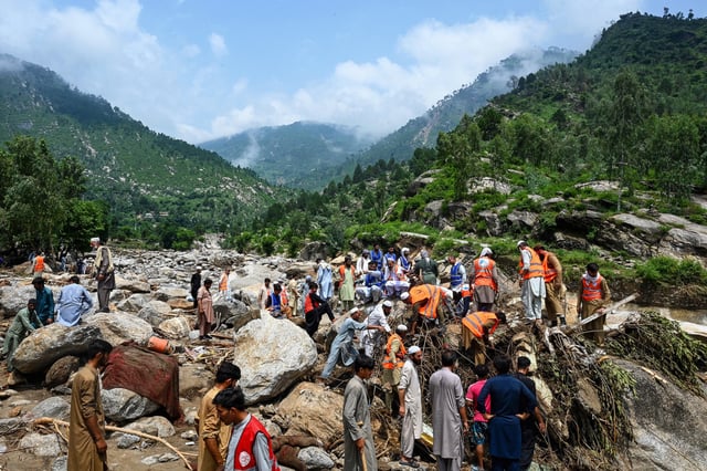 Flood survivors assist rescue personnel to remove heavy rocks and clear remains of damaged buildings in the Buner district of mountainous Khyber Pakhtunkhwa province on August 17, 2025. 