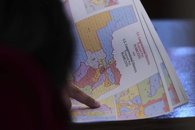 Texas state Rep. Marc LaHood looks over a map as lawmakers prepare to debate a redrawn U.S. congressional map in Texas during a special, Wednesday, Aug. 20, 2025, in Austin, Texas. (AP Photo/Eric Gay)