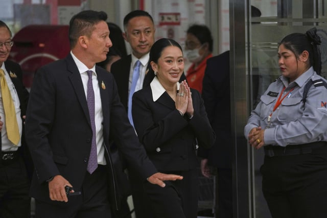 Thailand's suspended Prime Minister Paetongtarn Shinawatra, center, arrives at Constitution Court to give testimony in Bangkok, Thailand, Thursday, Aug. 21, 2025. (AP Photo/Sakchai Lalit)