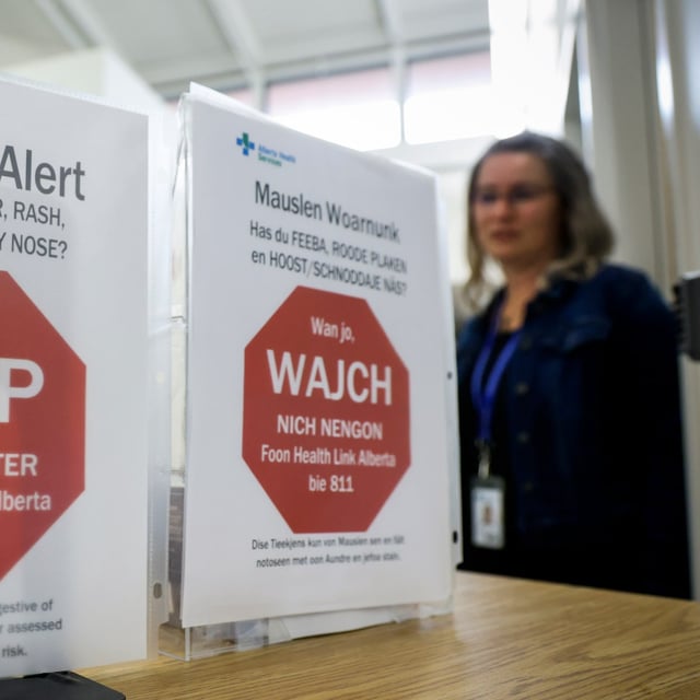 Signs in English and Low German warn of a measles alert at the Taber Community Health Clinic in Taber, Alta., Taber, Monday, July 28, 2025. THE CANADIAN PRESS/Jeff McIntosh