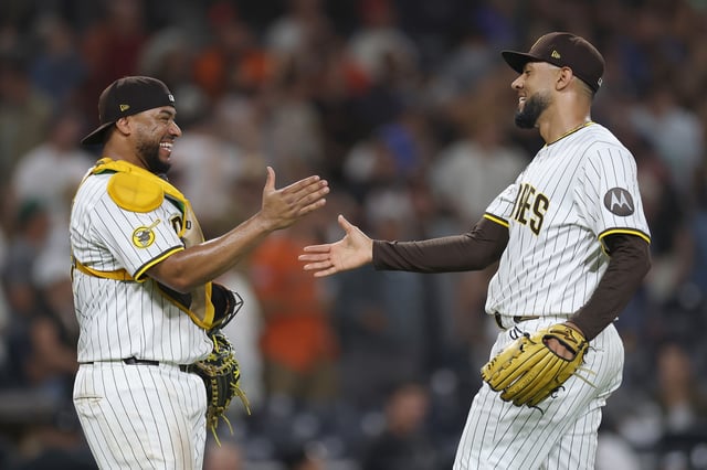SAN DIEGO, CALIFORNIA - AUGUST 19: Elias Díaz #17 and Robert Suarez #75 of the San Diego Padres celebrate after defeating the San Francisco Giants 5-1 in a game at Petco Park on August 19, 2025 in San Diego, California.