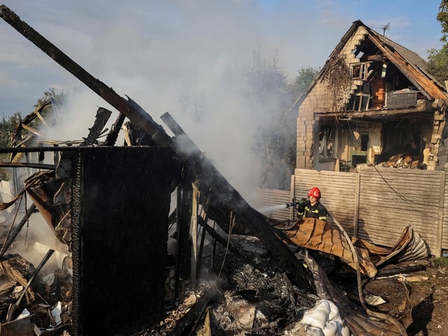 Un bombero trabaja entre las ruinas de casas en un aladea ucraniana atacada por Rusia. Foto: Reuters