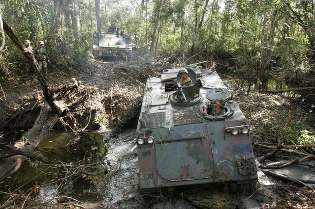 FILE - Guatemalan special forces soldiers try to cross a river during an anti-drugs operation in the National Park Laguna del Tigre, Guatemala, part of the Mayan Biosphere near the border with Mexico, March 6, 2006. (AP Photo/Moises Castillo, File)