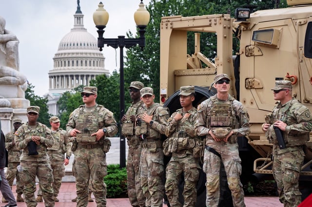 Protesters, police, and National Guard troops congregate at the entrance to Union Station in Washington, where Defense Secretary Pete Hegseth and Vice President JD Vance visited Wednesday, Aug. 20, 2025. (AP Photo/J. Scott Applewhite)