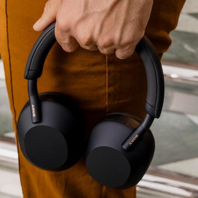 close up of person carrying Sony WH-1000XM5 headphones