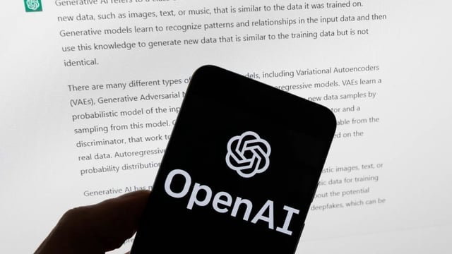 The OpenAI logo appears on a smartphone in front of a computer screen showing ChatGPT output, March 21, 2023, in Boston. (AP Photo/Michael Dwyer, File)