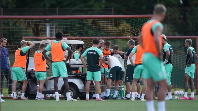 Eine Traube an Werder-Spielern bildet sich um Olivier Deman auf dem Trainingsplatz.