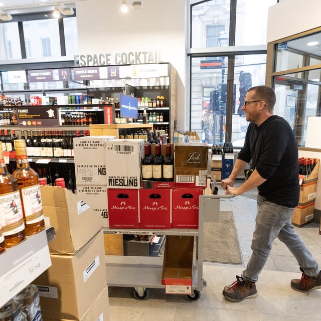 An employee removes American wines from an SAQ liquor store in Montreal on Tuesday, March 4, 2025. THE CANADIAN PRESS/Christinne Muschi