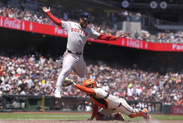 SAN FRANCISCO, CALIFORNIA - JUNE 22: Abraham Toro #29 of the Boston Red Sox is out at home plate after leaping over catcher Patrick Bailey #14 of the San Francisco Giants in the top of the fourth inning at Oracle Park on June 22, 2025 in San Francisco, California.