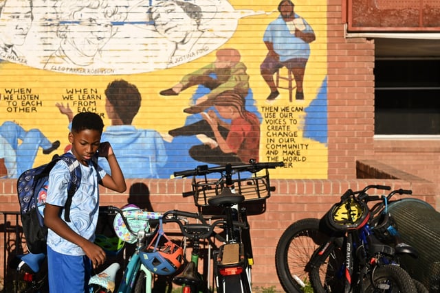 Ten-year-old Neko Beckham locks his bike up before heading in for the first day of the 2025–26 academic year at Columbine Elementary School in Denver, on Aug. 18, 2025. Beckham is starting 5th grade. (Photo by RJ Sangosti/The Denver Post)