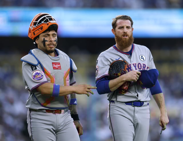 Paul Blackburn #58 and Francisco Alvarez #4 of the New York Mets react to the dugout for help with their radio communication during the first inning against the Los Angeles Dodgers at Dodger Stadium on June 02, 2025 in Los Angeles.