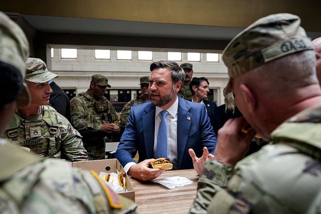 Vice-President JD Vance eats a Shake Shack hamburger with members of the National Guard during a visit to Union Station on Aug. 20, 2025, in Washington, D.C. The Trump administration has deployed federal officers and the National Guard to the district in order to place the city's Metropolitan Police Department under federal control and assist in crime prevention in the nation's capital.