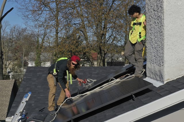 FILE - Theodore Tanczuk, left, and Brayan Santos, of solar installer YellowLite, put solar panels on the roof of a home in Lakewood, Ohio, April 17, 2025. (AP Photo/Sue Ogrocki, File)
