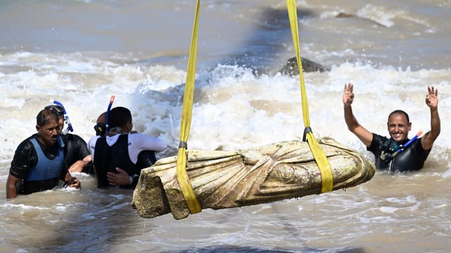 Divers celebrate one of the relics being lifted out of the water at Abu Qir Bay