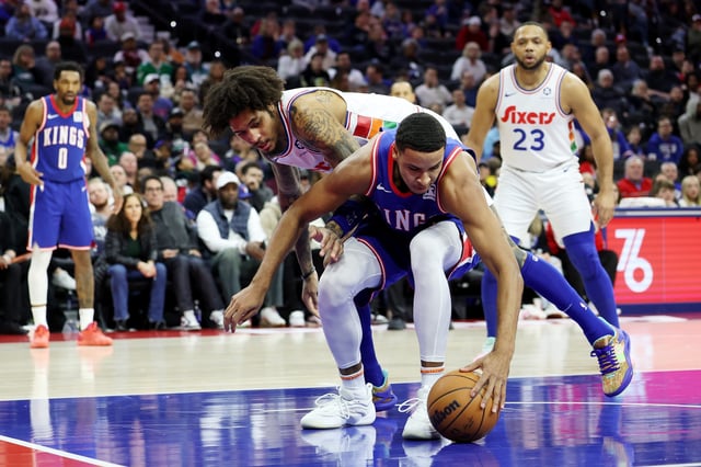 PHILADELPHIA, PENNSYLVANIA - JANUARY 29: Keegan Murray #13 of the Sacramento Kings and Kelly Oubre Jr. #9 of the Philadelphia 76ers reach for the ball during the second half at the Wells Fargo Center on January 29, 2025 in Philadelphia, Pennsylvania.