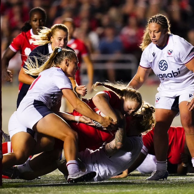 Canada's Olivia DeMerchant (18) scores a try as she is tackled by USA's Erica Jarrell-Searcy (5), bottom, and McKenzie Hawkins (10), left, during the second half of Women's rugby action in Ottawa on Friday, Aug. 1, 2025. THE CANADIAN PRESS/Sean Kilpatrick