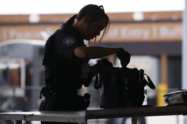 U.S. Customs and Border Protection officers search bags with the help of a canine at the Peace Bridge Port of Entry in Buffalo, N.Y. on Tuesday, May 23, 2023.THE CANADIAN PRESS/Cole Burston