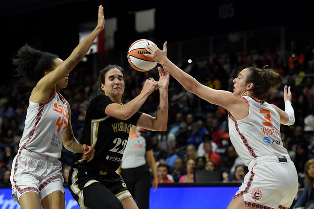Marina Mabrey #3 of the Connecticut Sun gets the ball away from Sonia Citron #22 of the Washington Mystics as teammate Leila Lacan #47 helps to defends during the second quarter of the game at Carefirst Arena on August 19, 2025 in Washington, DC.