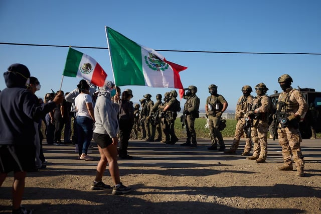 Trabajadores en una granja de California desafían con banderas mexicanas a agentes del ICE durante una redada