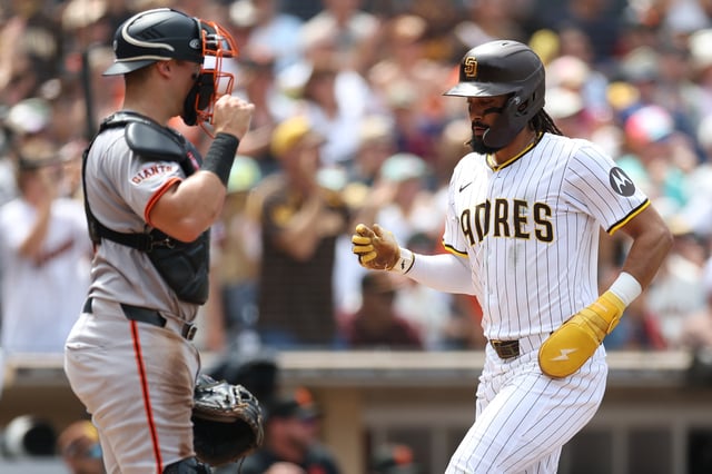 SAN DIEGO, CALIFORNIA – AUGUST 21: Fernando Tatis Jr. #23 scores on an RBI single hit by Manny Machado #13 of the San Diego Padres as Andrew Knizner #21 of the San Francisco Giants looks on during the fourth inning of a game at Petco Park on August 21, 2025 in San Diego, California. (Photo by Sean M. Haffey/Getty Images)
