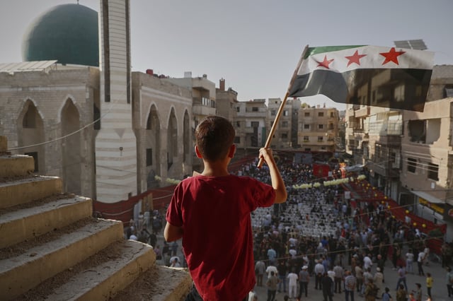 Syrians gather to mark the anniversary of a chemical weapons attack carried out by Bashar Assad's forces in Eastern Ghouta in 2013, in the town of Zamalka on the outskirts of Damascus, Syria, Thursday, Aug. 21, 2025. (AP Photo/Omar Sanadiki)