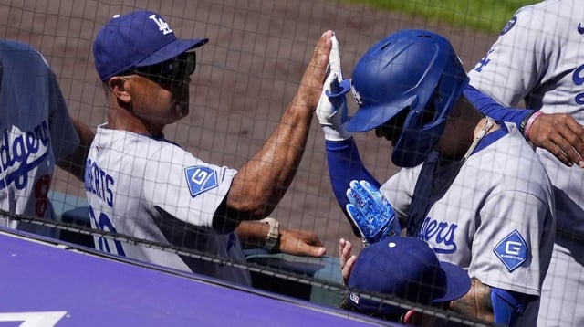 Los Angeles Dodgers manager Dave Roberts (30) high fives center fielder Andy Pages (44) following his solo home run in the inning at Coors Field. Mandatory Credit: Ron Chenoy-Imagn Images
